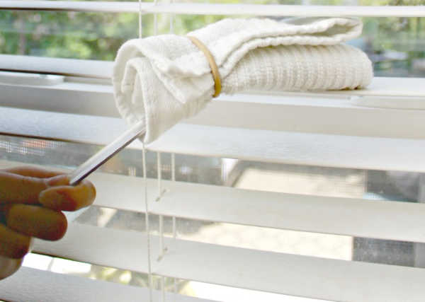 Do you need to clean your blinds but keep putting the task off? Learn how to clean blinds quickly and easily with these easy tips. Blinds being cleaned with a cleaning wand.