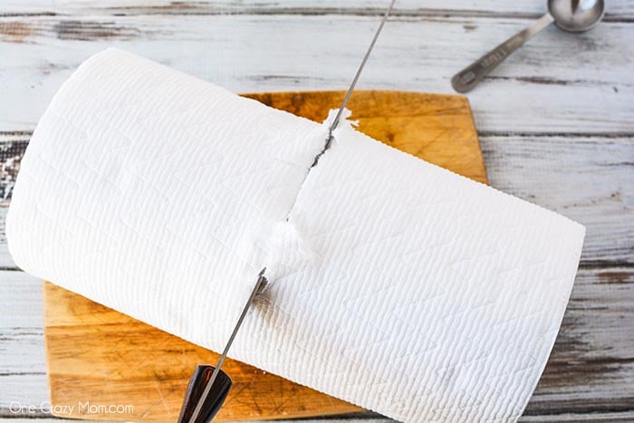 Cutting paper towels with a knife on a cutting board