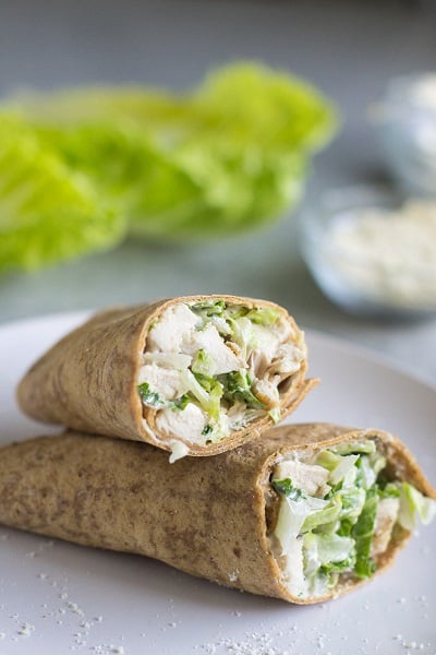 Find lots of healthy school lunch ideas here! 30 healthy back to school lunch ideas that are quick, easy and kid approved! Chicken Caesar Wrap on a white plate cut in half.