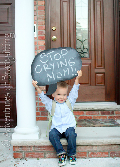 Here are 10 fun first day of school picture ideas. These first day of school picture ideas are perfect for back to school. Try one of them this year! Stop crying sign on chalkboard held by child.