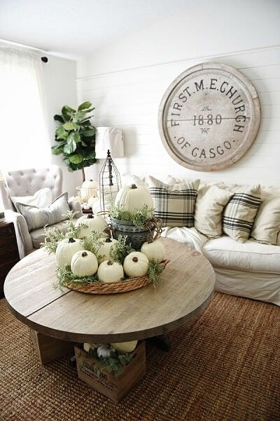 Neutral centerpiece with white pumpkins in a basket.