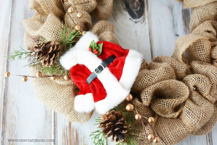 Santa suit and floral picks attached to wreath.
