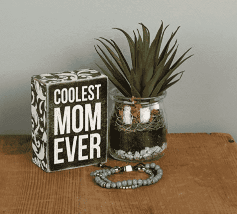 Coolest mom sign beside a vase.