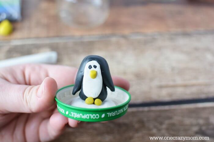 Penguin attached to lid of jar.