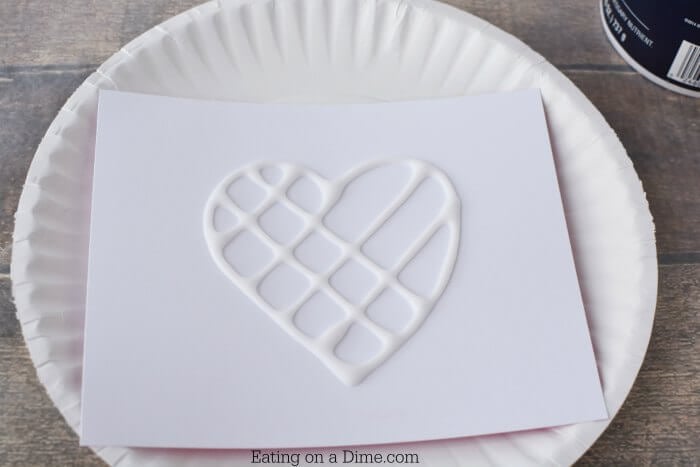 Cardstock with glue design on a paper plate.