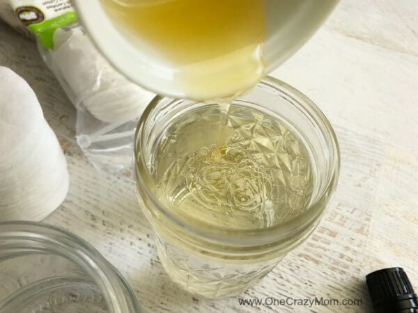 Coconut oil being poured into water in the jar.