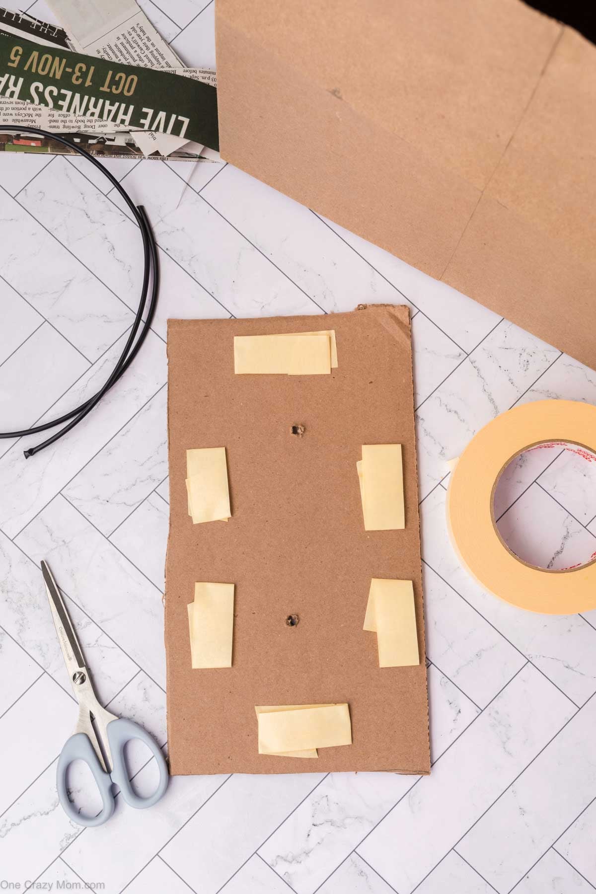 Masking tape attached to cardboard strip.