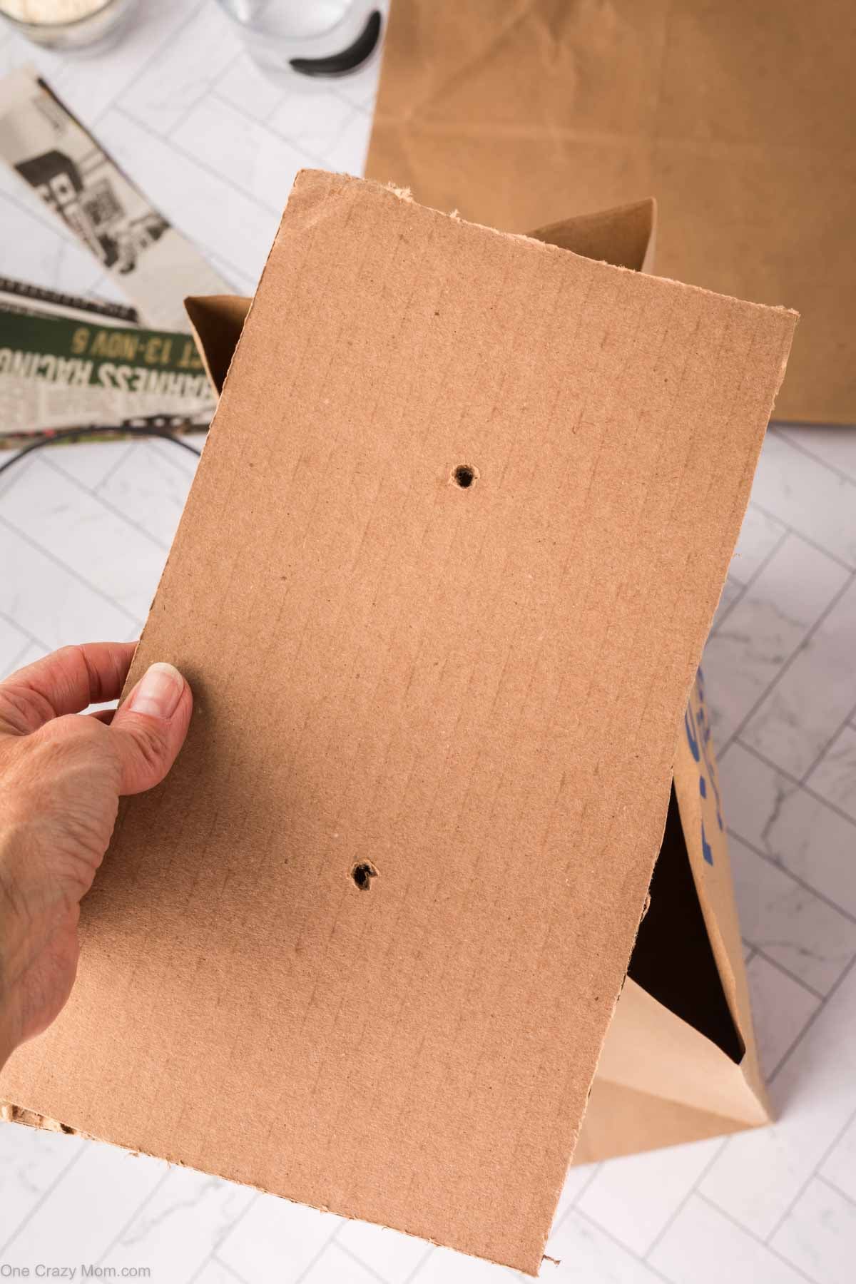Holes poked in cardboard strip.