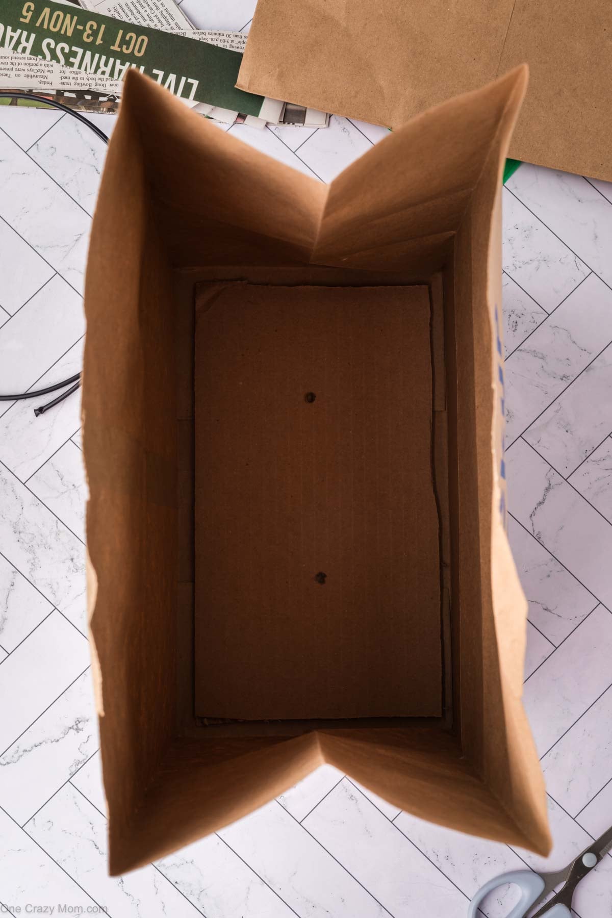 Cardboard strip placed in the bottom of the grocery bag.