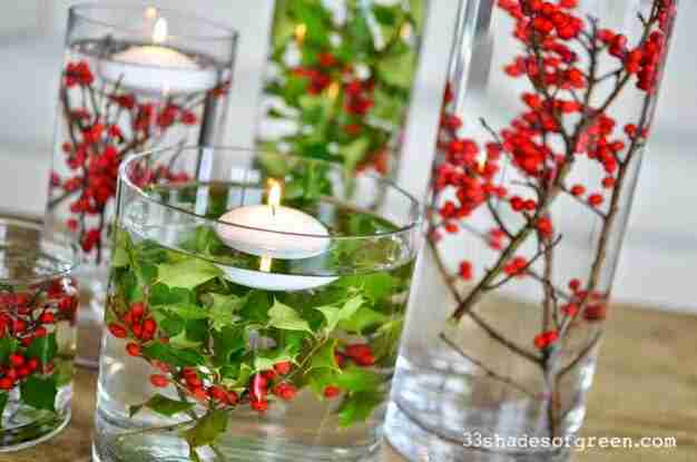 Glass vases with holly and floating candles.