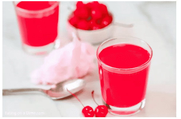 Cotton Candy drink in glass beside a spoon.
