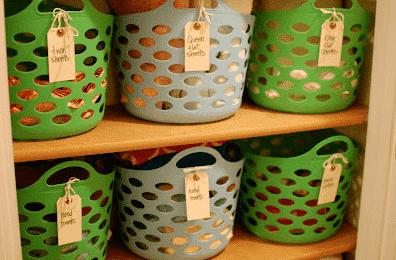 Baskets in linen closet with sheets.