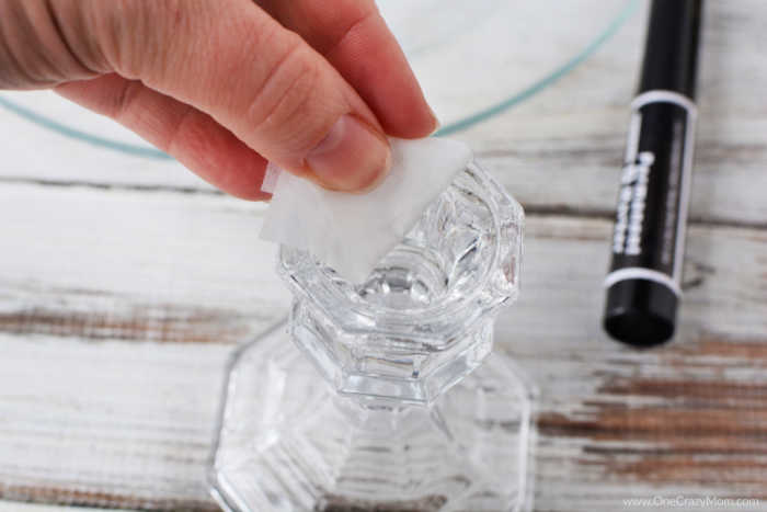 Top of candle stick being rubbed with a cotton ball soaked in rubbing alcohol.