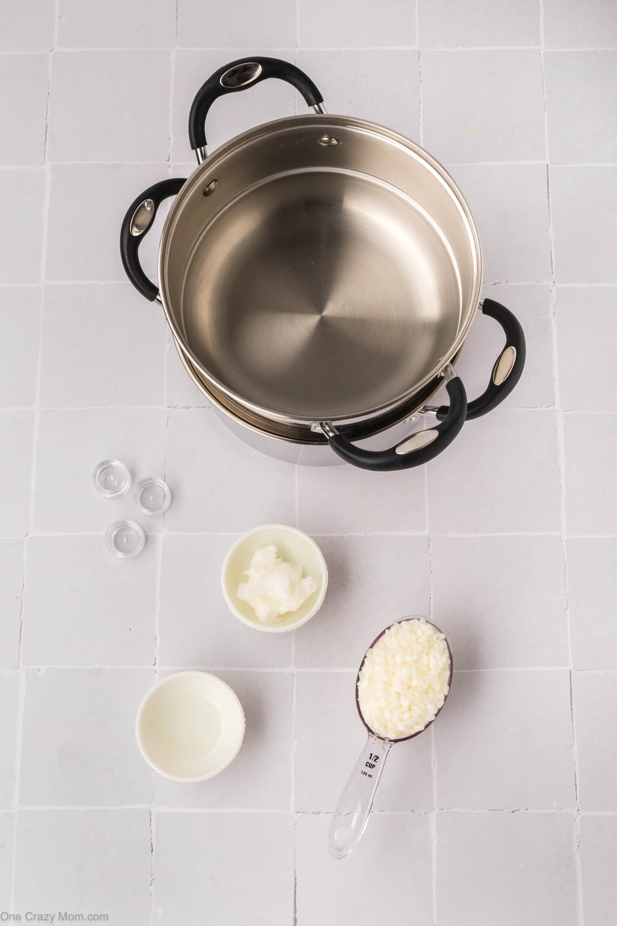 Supplies for homemade lip balm - beeswax, coconut oil, almond extract, containers, double boiler.