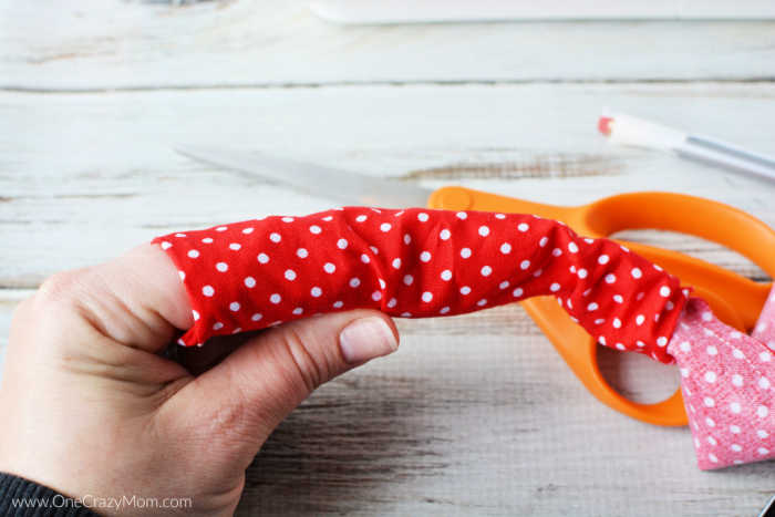 Finger threaded through fabric tube.