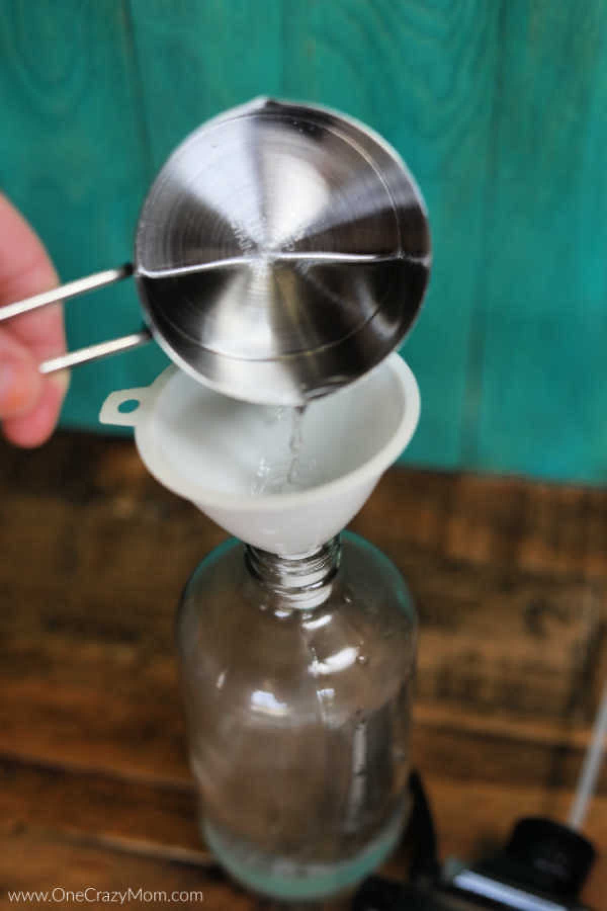 Funnel being used to pour witch hazel into bottle.