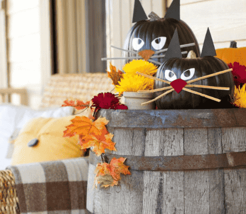 Black cat pumpkin on stand.