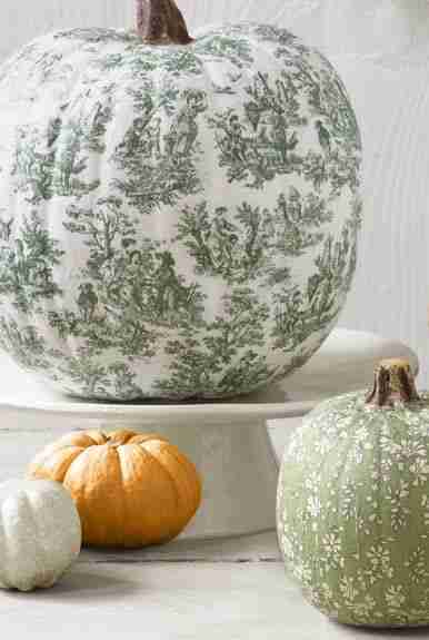 Decoupage pumpkins on a stand.