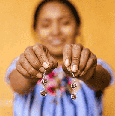 Woman holding earrings.