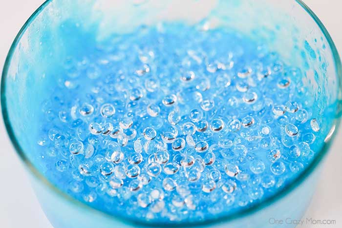 Beads added to slime mixture in a bowl.