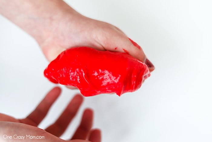 Squeezing red slime together by hands