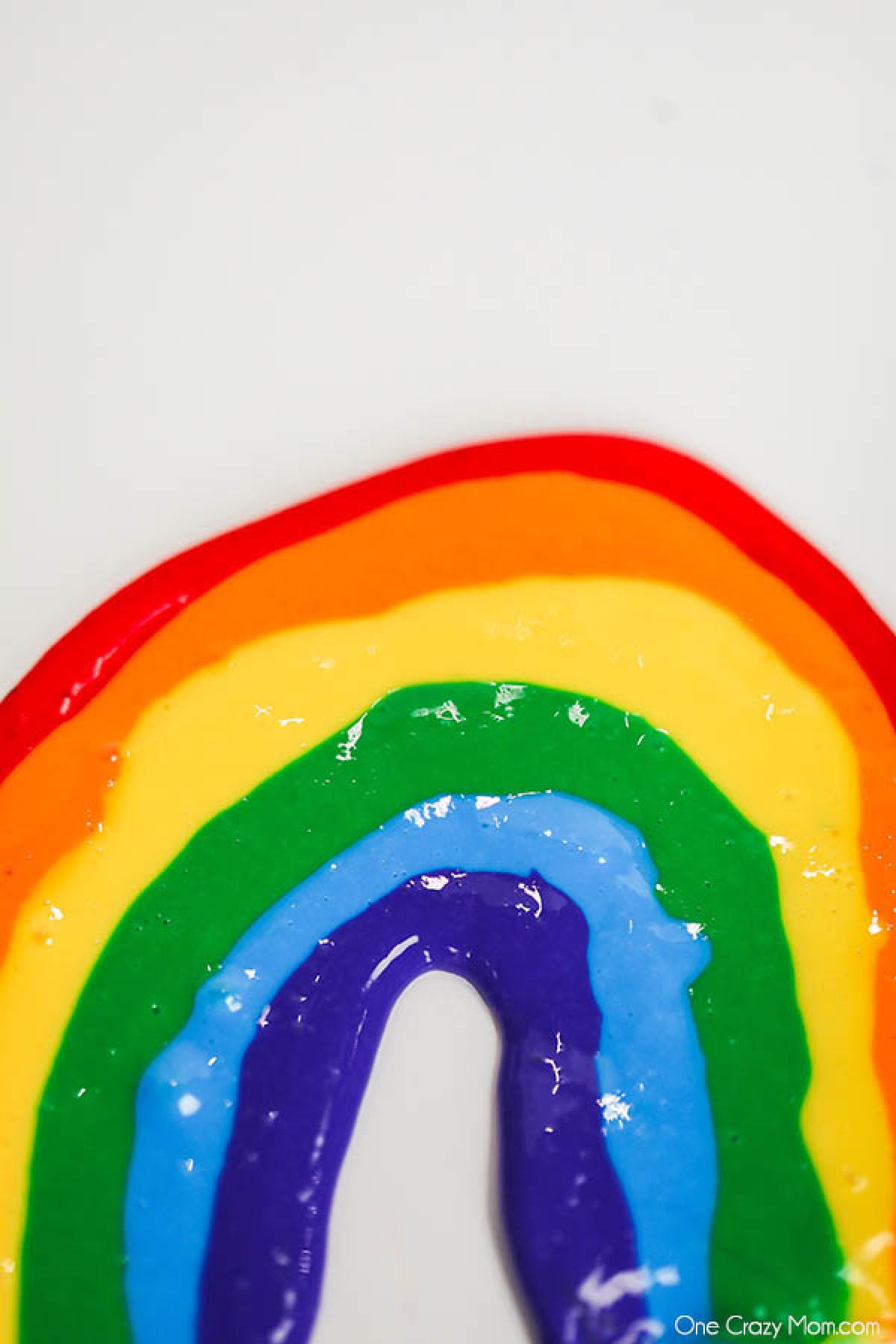 Slime that is shaped into a rainbow that includes red, orange, yellow, green, and blue colors