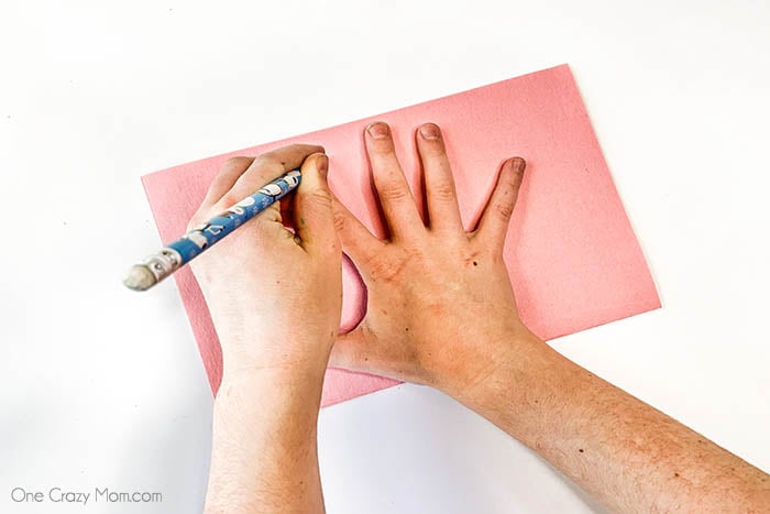 Hand being traced on paper.
