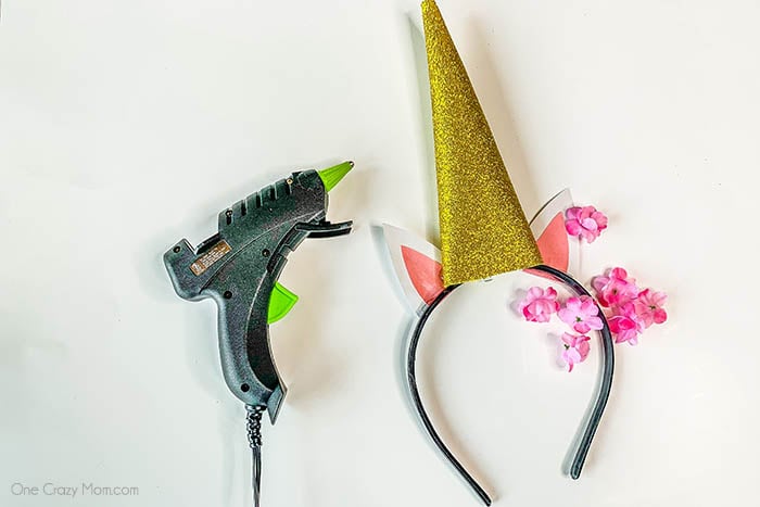 Flowers glued on headband beside ears.