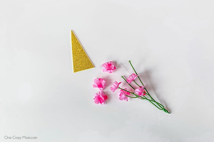 Glitter paper cut out into triangle shape with flowers.