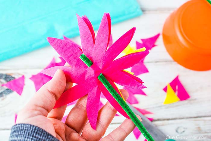 Pipe cleaner threaded through flower.
