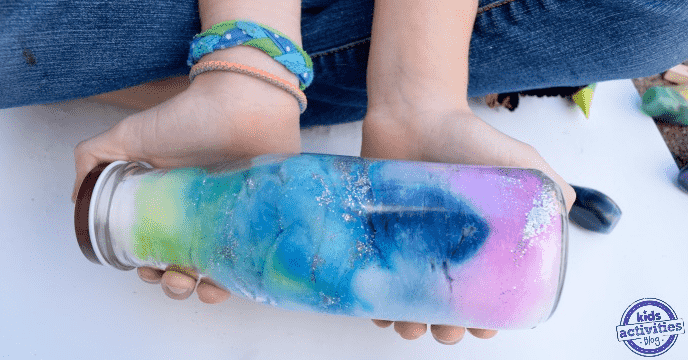 Sparkling galaxy jar in hands.