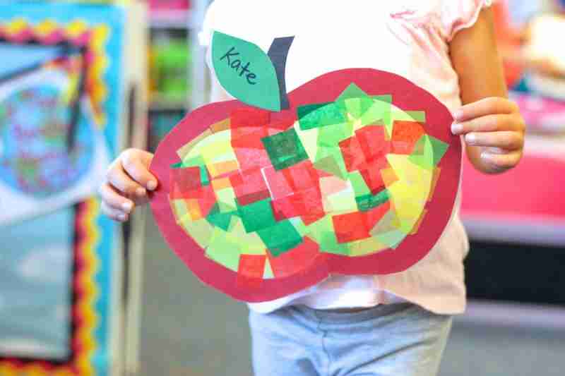 Child holding stained glass apple.