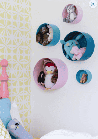 Hatboxes on the wall with stuffed animals.