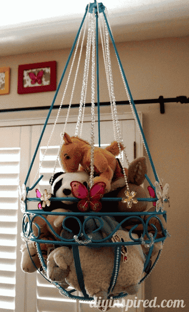 Hanging planter with stuffed toys.