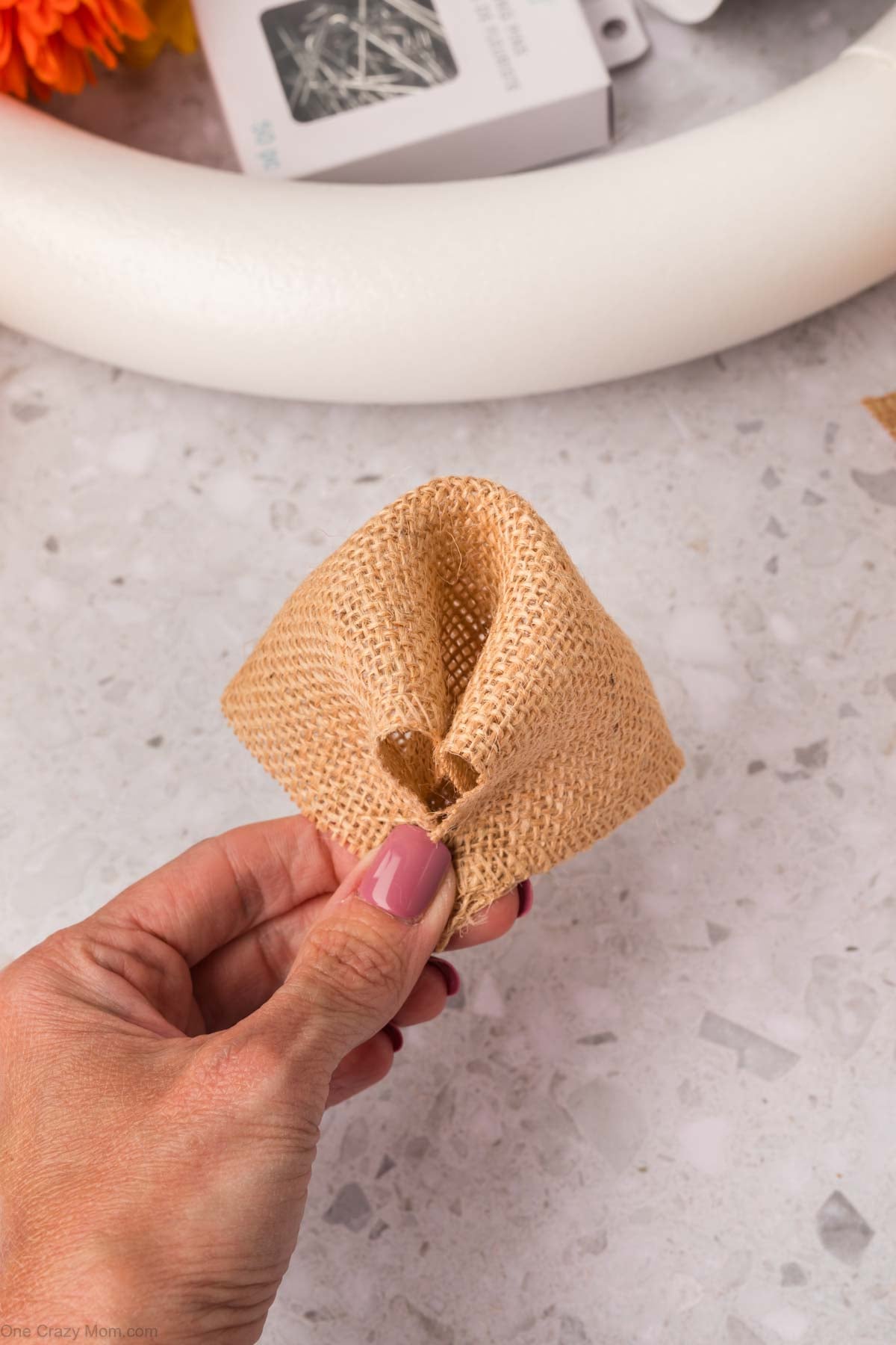 All corners of the burlap square pinched together.