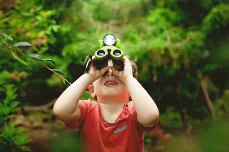 Child with binoculars playing I Spy.