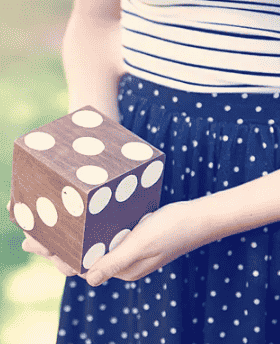 Giant yard dice in hands.