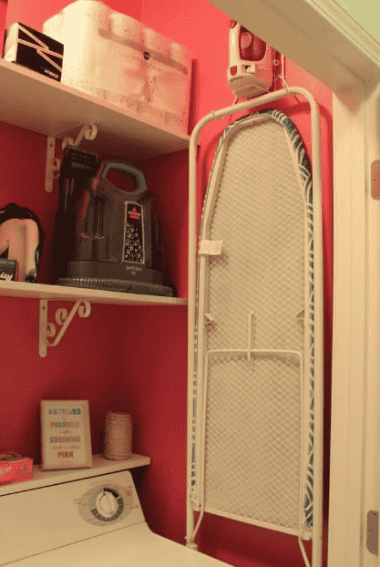 Wall mounted ironing board in laundry room.