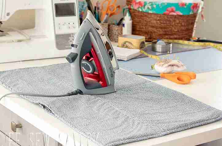 Ironing pad on table with iron.
