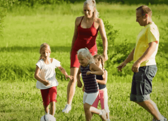 Family playing soccer together.