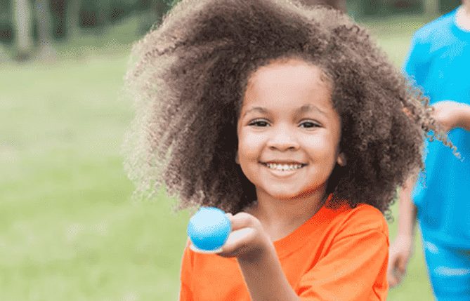 Child playing egg and spoon race.