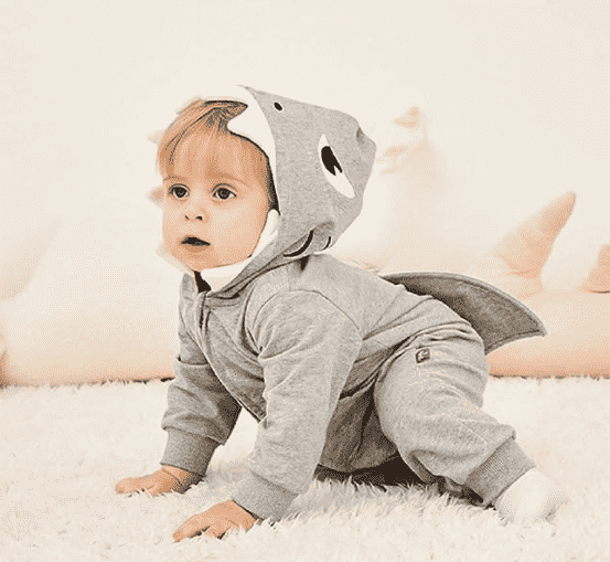 Child in baby shark costume crawling.