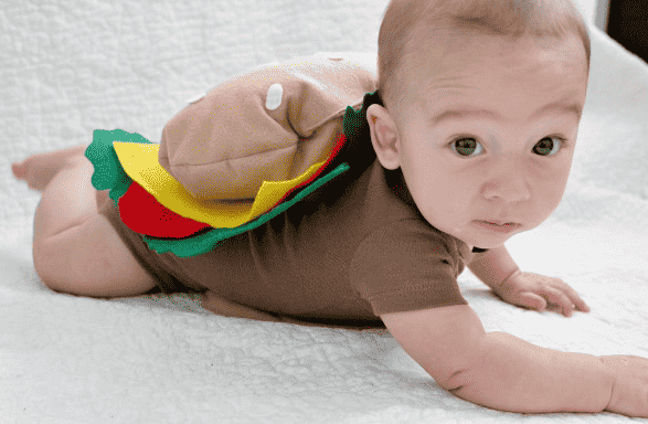 Baby in burger costume crawling.