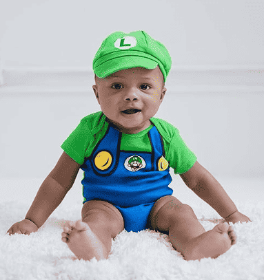 Child in Luigi costume sitting on the floor.