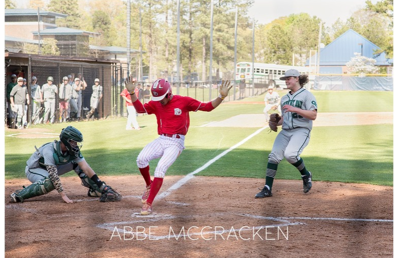 Baseball player sliding into base.
