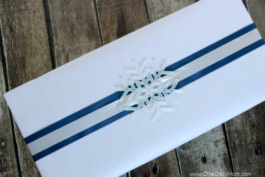 Check out these frugal and creative Christmas gift wrap ideas. Remember, a Christmas gift wrapping idea doesn't have to be hard or expensive. Box wrapped in white paper and topped with an ornament.
