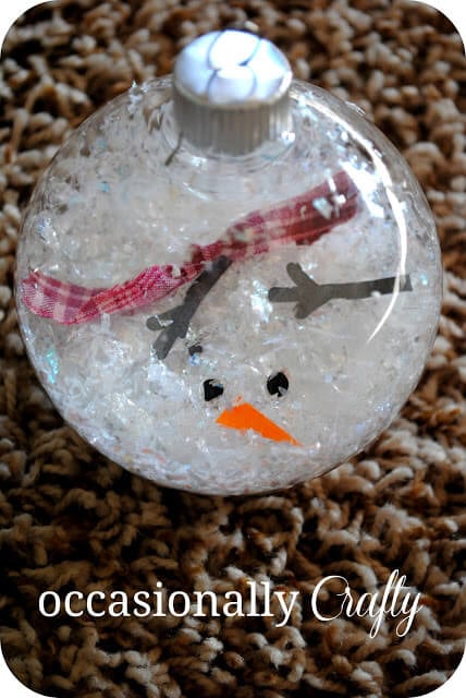 We've rounded up over 30 Easy Homemade Christmas Ornaments. These DIY ornament ideas are simple to make and many use what you already have. Try these fun DIY craft ideas! Your kids will love making these easy handmade ornaments for Christmas! #onecrazymom #christmasornaments #DIYornaments Melted Snowman Ornament ready to hang on tree.