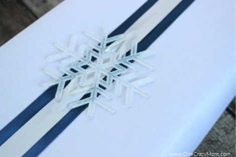 Check out these frugal and creative Christmas gift wrap ideas. Remember, a Christmas gift wrapping idea doesn't have to be hard or expensive. Box topped with a snowflake ornament.