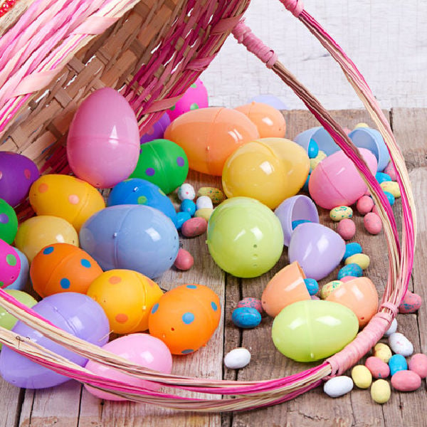 An Easter Basket that has fallen over and candy and Easter eggs have fallen out of the basket.