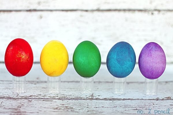 We have 25 Easter egg decorating ideas that are so easy and the kids will love. Gather the family together and make lots of sweet memories with these ideas. Rainbow eggs on clear stand.
